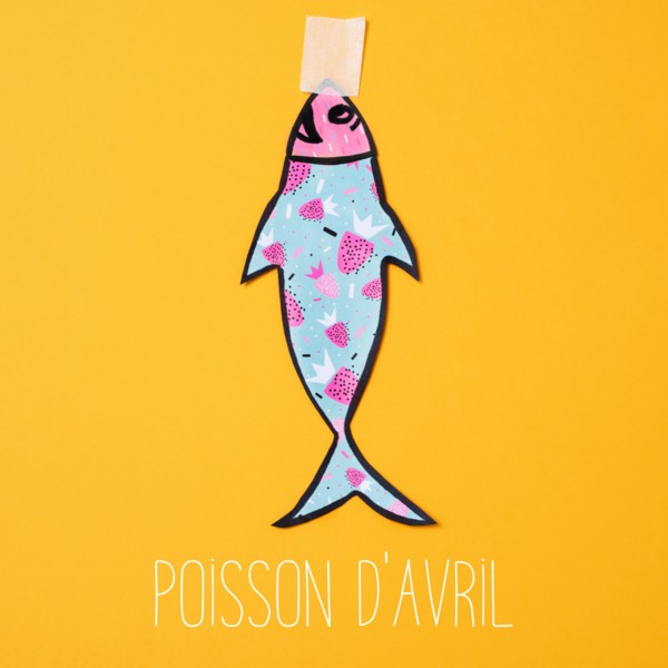 a homemade paper fish, made by myself, attached with adhesive tape to an orange background and the text poisson d avril, april fools day in french