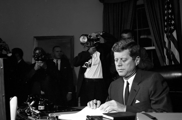 23 October 1962
Proclamation signing, Interdiction of the Delivery of Offensive Missiles to Cuba, 7:05PM.
[White spotting throughout negative.]

Please credit "Cecil Stoughton. White House Photographs...