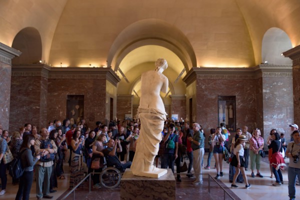 People around Venus de Milo (Aphrodite of Milos), one of the most famous ancient Greek sculpture, on display at the Louvre Museum in Paris, France