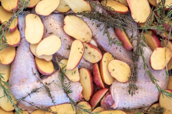 Food, preparation, black chicken, halved potatoes, rosemary, Christmas dinner.