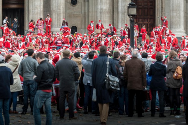 London, UK. 14th December, 2013.  Hundreds of Santas gathering on the steps of St Pauls Cathedral before they march off to meet up with groups of other Santas to celebrate the annual Santacon.  Photog...
