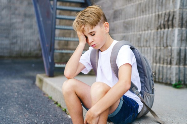 very sad boy bullying in school playground.