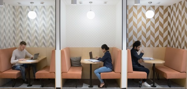 Workflow in modern coworking space of three diverse businesspeople
