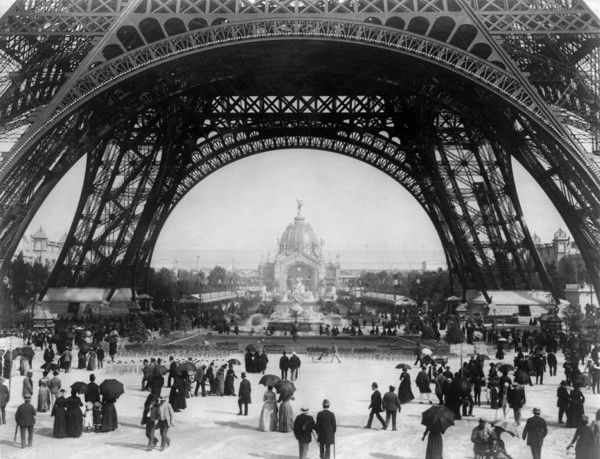Paris Exposition, view from ground level of the Eiffel tower with Parisians promenading, 1889