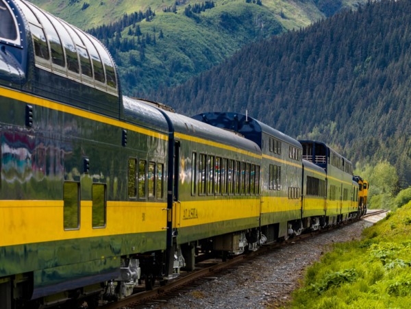 Snow capped mountains in background of Alaska Railroad’s Coastal Classic train from Anchorage to Seward Alaska