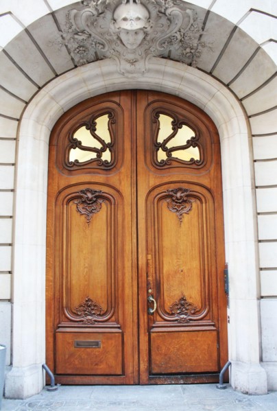 Old fashioned front door entrance, white facade and brown door, Paris, France