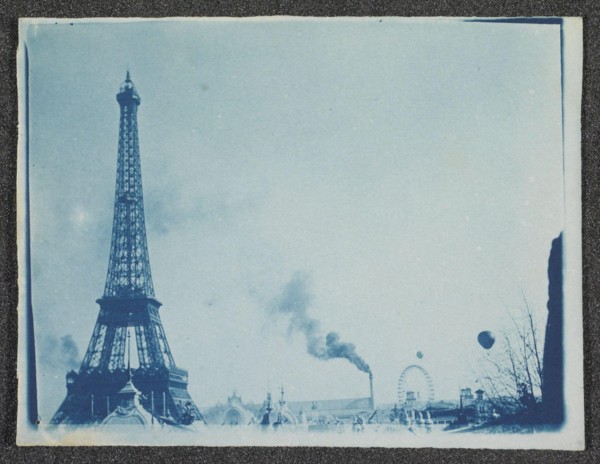 Gezicht op terrein van de Exposition Universelle met Tour Eiffel, Parijs 1900 View the site of the Exposition Universelle with smoking chimney, big wheel, airships and Tour Eiffel, 1900. Manufacturer ...