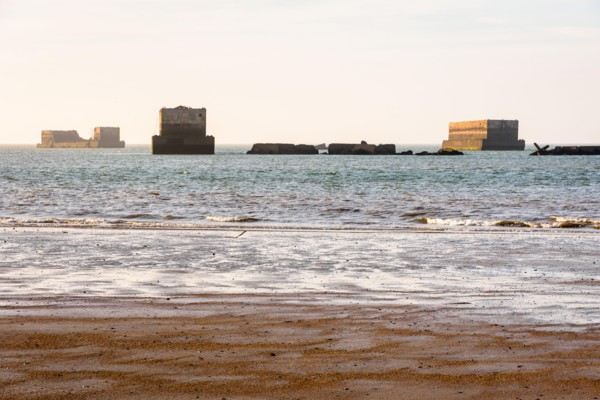 Remains of Phoenix caissons used to build the artificial Mulberry harbour on Gold Beach in Arromanches, France, after the Normandy landings in WWII.