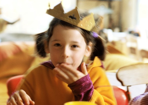 Child with paper crown on head, portrait.