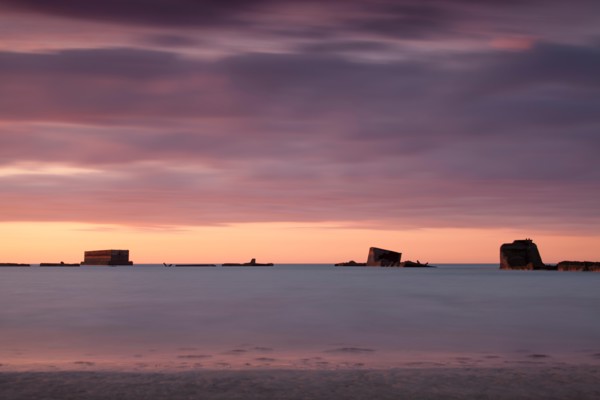 Parts of the remains of the Mulberry Harbour on gold beach Asnelles Calvados Normandy captured at sunset