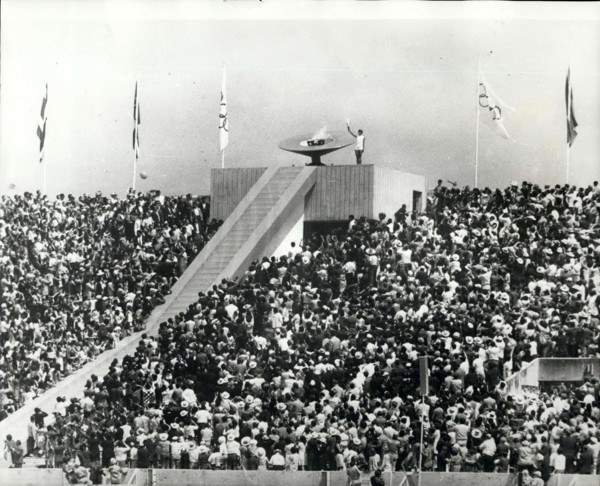 1968 - Opening of the Olympic Games Lighting the Flame: Photo Shows 20-year old Mexican athlete Enriqueta Basilio, is seen lighting the Olympic Flame Torch - the first woman in the history of modern O...