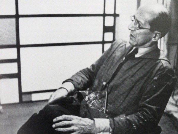 Photograph of the famous Dutch artist Piet Mondrian (7th March 1872 - 1st February 1944). He is shown seated infront of one of his pieces of work. The photograph was taken around 1942.