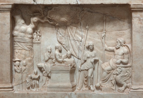Munich Votive Relief. Greek votive relief from about 220 BC on display in the Glyptothek Museum in Munich, Bavaria, Germany. In a rural sanctuary a sacrificing family approach Asclepius, the god of he...