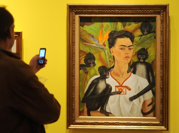 A visitor takes a picture of the painting 'Portrait with Apes' by Frida Kahlo in a retrospective in the Martin-Gropius-Bau in Berlin, Germany, 29 April 2010. The largest exhibition ever about Mexican ...