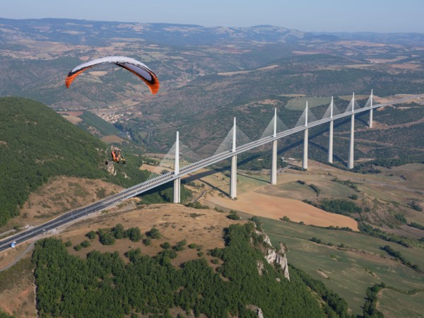 AIR-TO-AIR VIEW. Paramotor flying in the vicinity of the Millau Viaduct, the world's tallest bridge as of 2020. Millau, Tarn Valley, Aveyron, France.