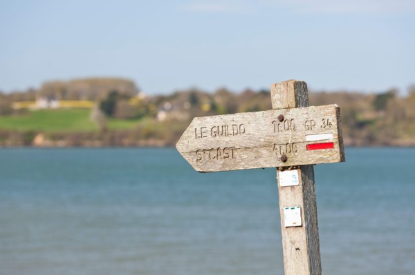 The old wooden sign shows coastal hikers the way to Saint Cast le Guildo along the GR34 long-distance hiking trail between St. Malo and Cap Frehel, Brittany, France