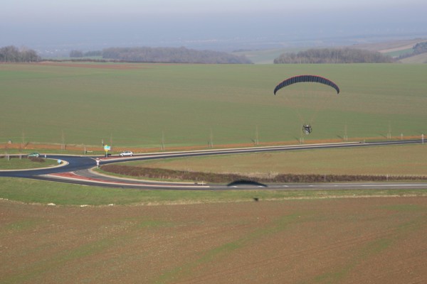 Aerial photograph of a paramotor (motorized paraglider) flying over a roundabout in soindres fields, Yvelines department (78200), Ile-de-France region