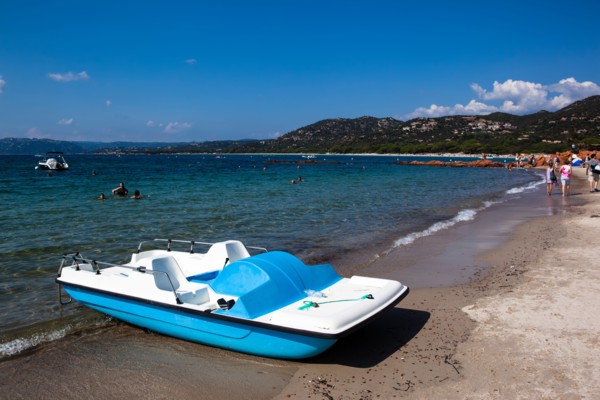 Paddle boat and curvy sandy beach perspective of Palombaggia, Corsica, France