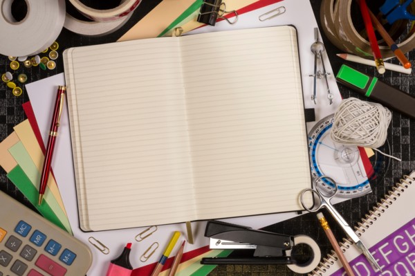 Selection of stationery for the office or for going back to school or college - Open book with space for text.