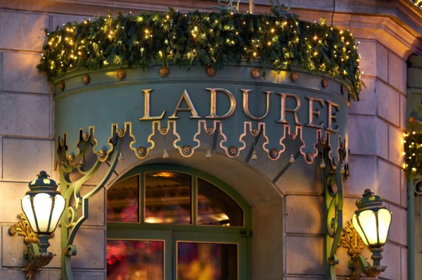 Laduree Champs Elysees. Beautifully lit, elegant entrance to the French luxury bakery and sweets maker house. PARIS, FRANCE - December 29, 2018
