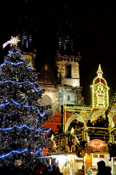 Christmas Prague at night. Glowing Christmas tree and beautiful decoration in front of Church of Our Lady before Týn on Old town square