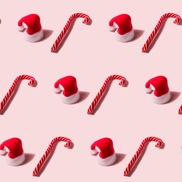 Trendy Christmas seamless texture with Santa Claus hat and candy cane. Modern christmas design