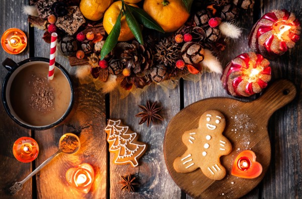 Christmas homemade gingerbread cookies, hot chocolate and candles on wooden table