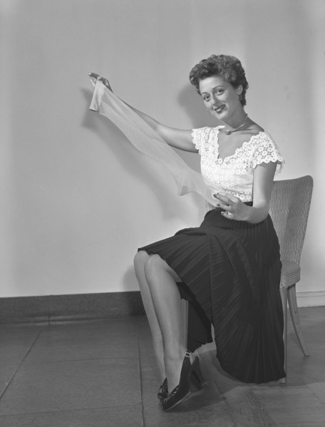 Nylon stockings in the 1940s. A young woman is holding a nylon stocking in her hands. The nylon stocking was very popular in the 1940s, a trendy accessory that was very expensive to buy during world w...