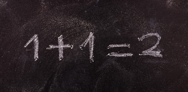 School maths concept. Math simple equation 1+1=2, isolated, on blackboard background.