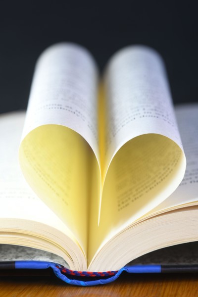 vertical heart shaped book pages showing spine ,selective focus on a black background concept of the love of reading