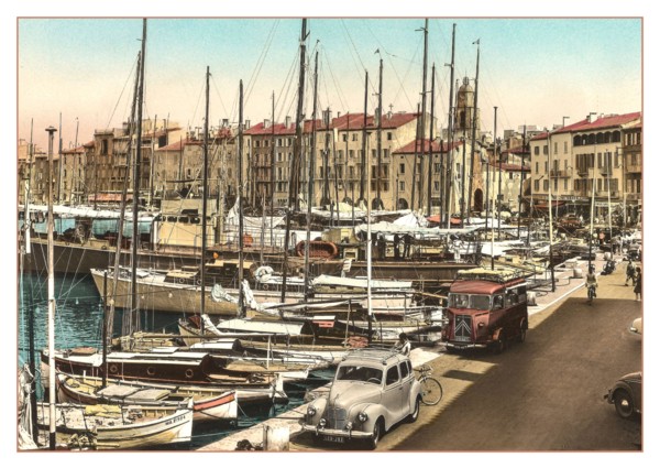 ST.TROPEZ Vintage 1950’s 1960's View of the harbour with fishing and sailing boats moored with French Citroen Van and Peugeot Motorcar parked, cafes and restaurants behind. Côte d’Azur South of France...