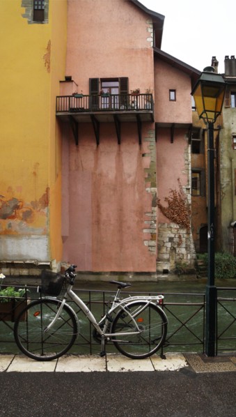 a classic street lantern next to a bicycle in front of the river against the backdrop of a traditional building, Annesy, France