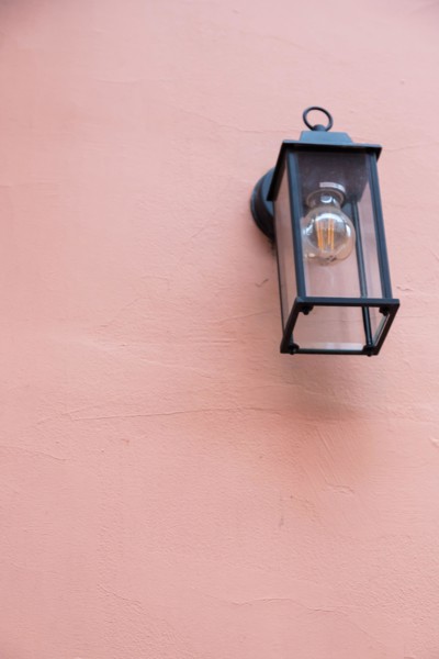 Old lantern with a white lamp. Wall color - Oriental Pink, Hue Red. Vintage lantern concept.