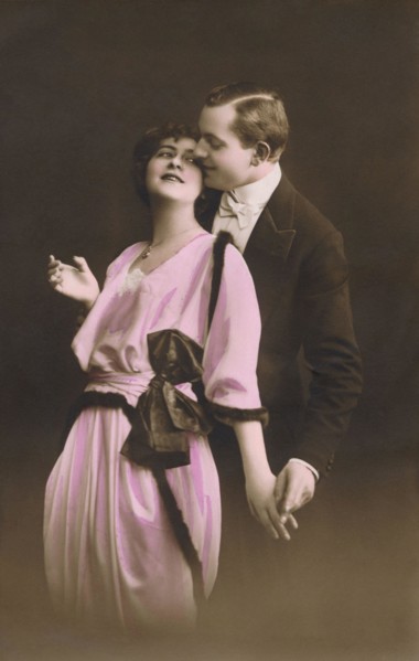 Vintage hand-coloured photograph of a romantic couple embracing. Adapted from an old postcard.