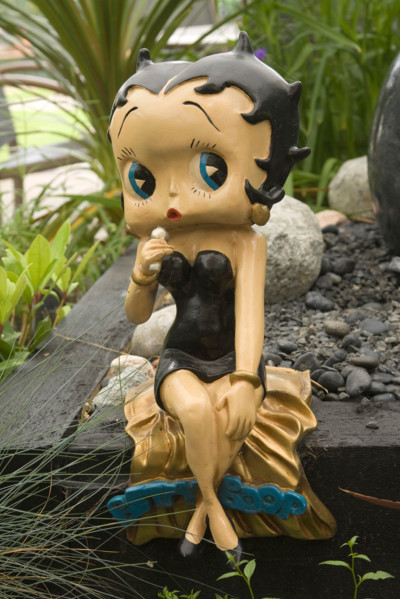 a statue of Betty Boop in a garden