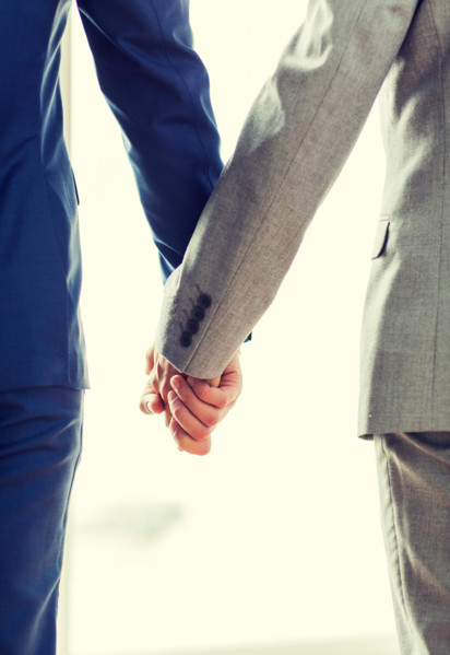 close up of male gay couple holding hands