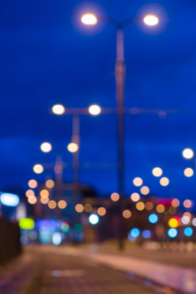 Blurred image of night city street with lamppost lights