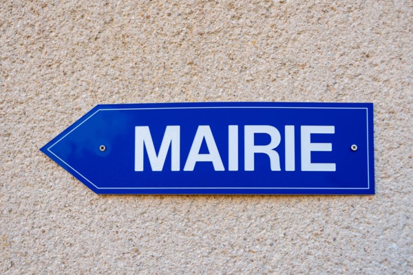 Blue directions sign on which is written the word "town hall" in French language. Close-up shot