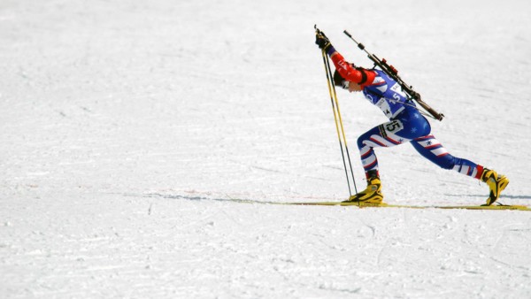 Competing in the Biathlon event, World class athlete Sergeant Kristina Sabasteanski, USA, keeps limber, with her .22 caliber, bolt-action rifle slung on her back, before her leg of the women's 4 X 7.5...