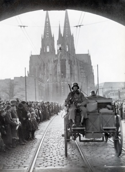 A photograph shows German troops crossing the Rhine into the Rhineland on March 7, 1936. This event marked a critical moment in Nazi Germany's aggressive expansion, as it violated the Treaty of Versai...