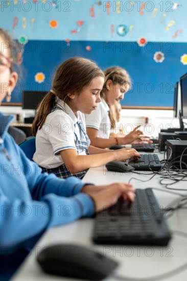 Elementary school student using a desktop computer during an information technology lesson in a modern classroom.