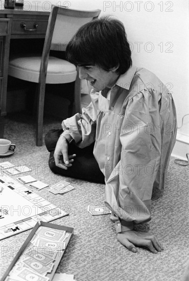Pop Group The Beatles August 1964 George Harrison playing monopoly at the Beatles Bel Air home in California during the tour of