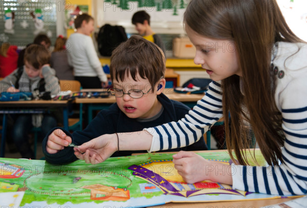 Non-disabled and disabled pupils (in this case a boy suffering from Down's syndrome) learn together in the same class.