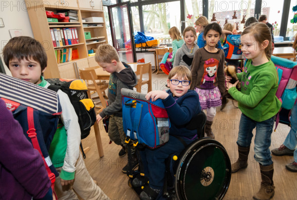 Non-disabled and disabled students (in this case a boy in a wheel chair) learn together in the same class in a primary school.