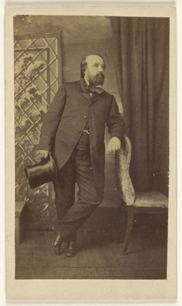 Full-bearded man holding a top hat, standing, leaning on chair back; Alexander Anderson, American, 1775 - 1870, 1860s; Albumen