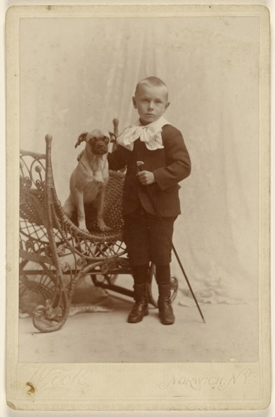 Little boy standing, holding a cane, with a little dog in a wicker chair; G. Wick, American, active Norwich, New York 1870s