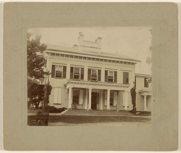 View of a large white house with pillars; about 1890; Gelatin silver print