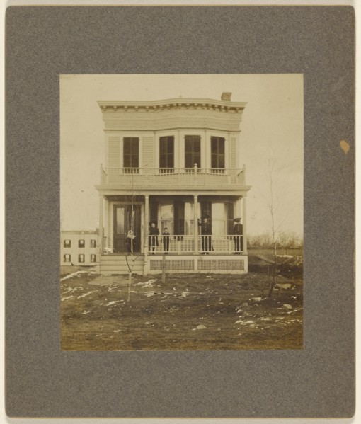View of a Victorian-style house with five people on the front porch; 1890s; Gelatin silver print