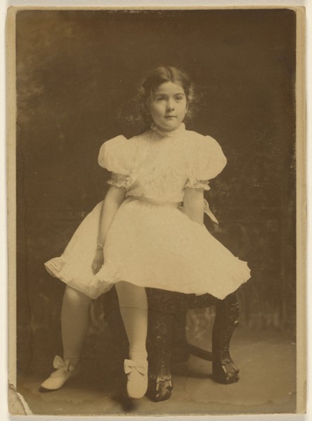 young girl in a white dress, seated; about 1920; Bromide print
