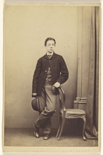 young man with derby in hand, with other hand on chair back, standing; Thomas Edge, British, active 1850s - 1870s, 1865-1870